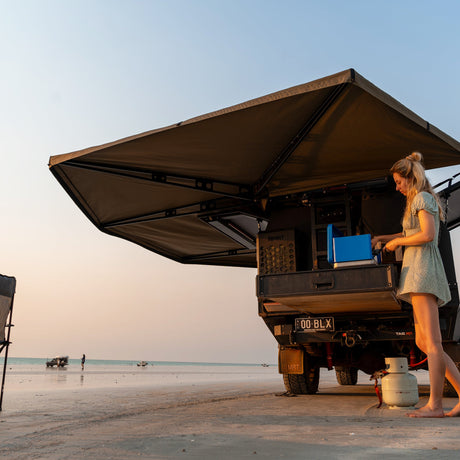 Woman at the rear of a ute under a 270 XT MAX Awning at dusk