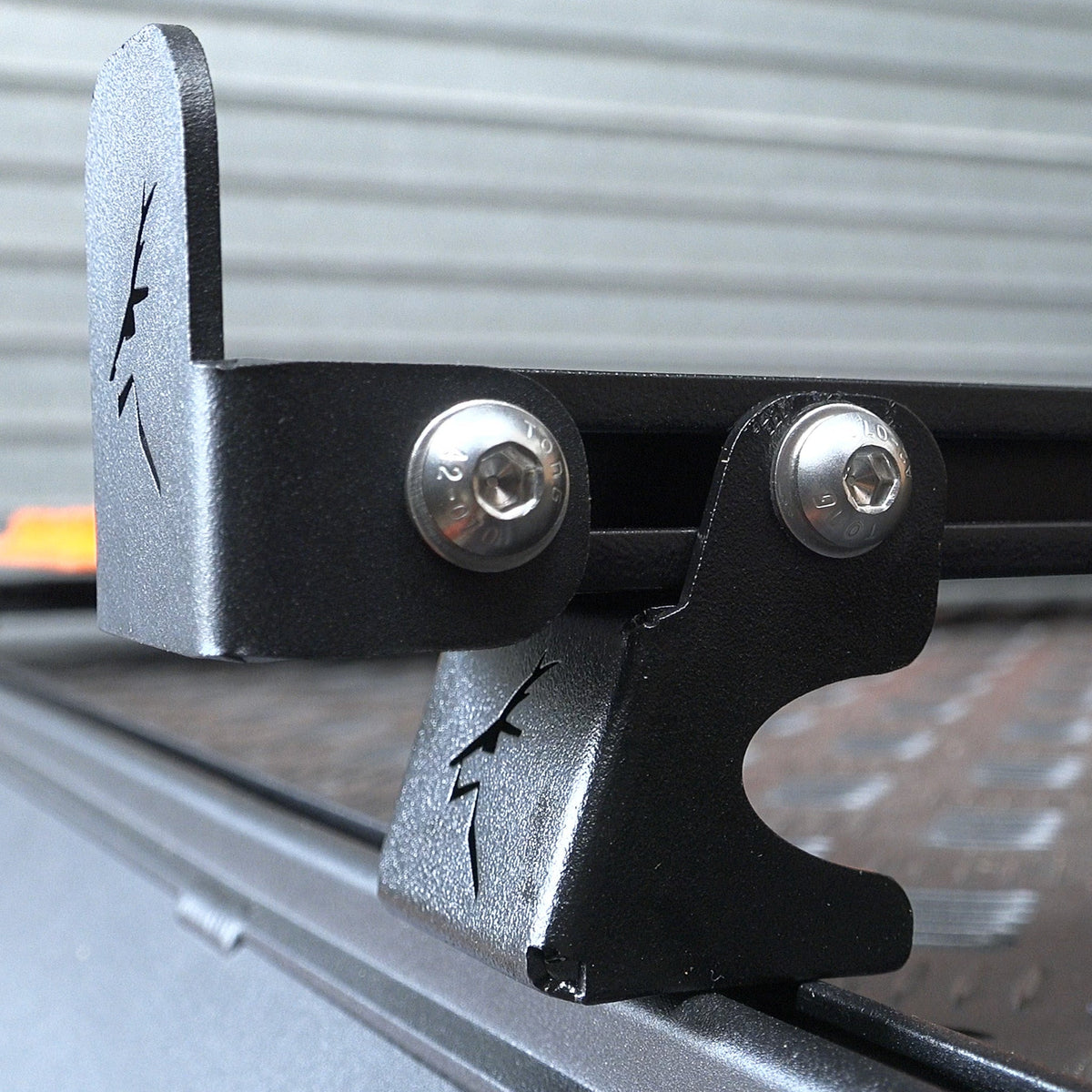 Close-up of a High Foot Mount bolted to a rooftop tent's Ezi-Slot rail