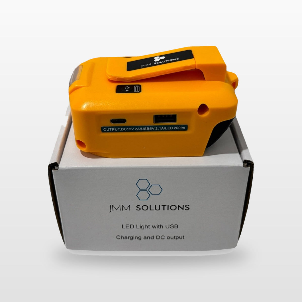 DeWalt-compatible USB & 12V Charger with LED Light: standing on its box